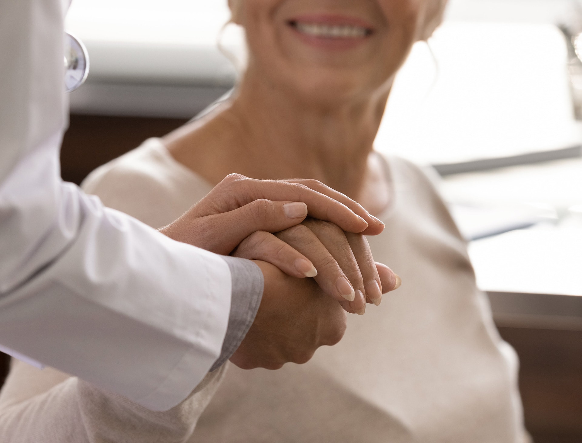 Dylan Neal PA-C holding a patients hand during a skin treatment at halo skin institute